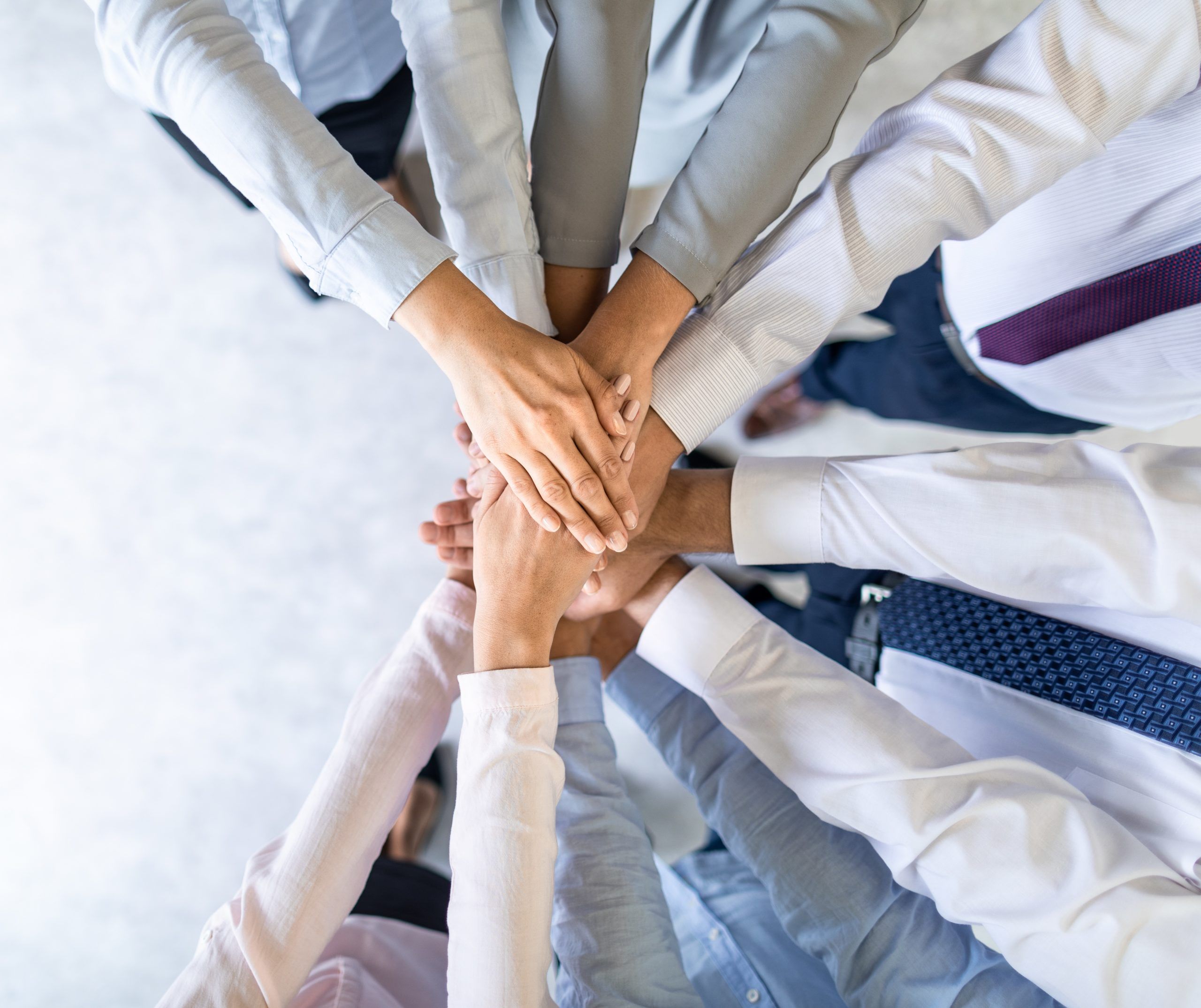 Close up top view of young business people putting their hands together. Stack of hands. Unity and teamwork concept.